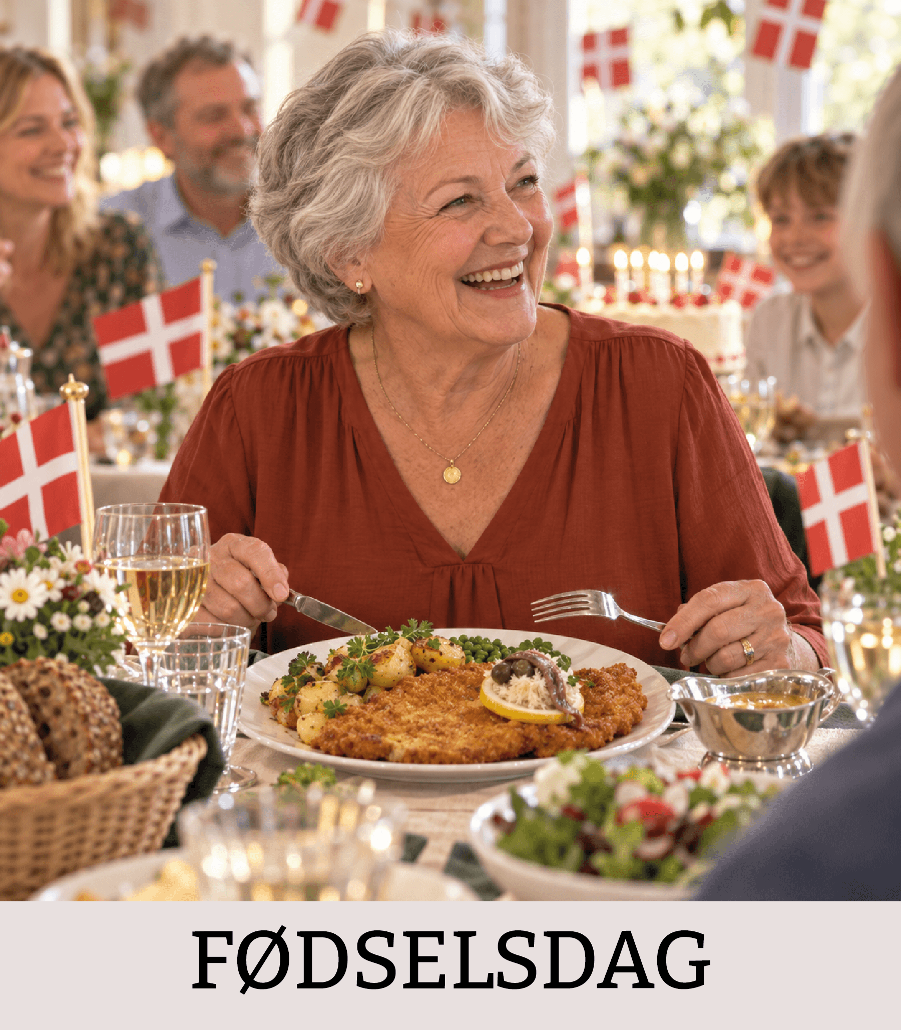 Ældre kvinde fejrer fødselsdag ved et festligt bord med wienerschnitzel og danske flag